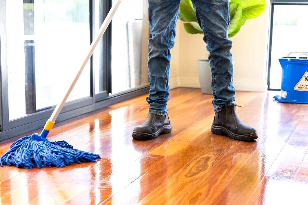 cleaner mopping a polished wooden floor
